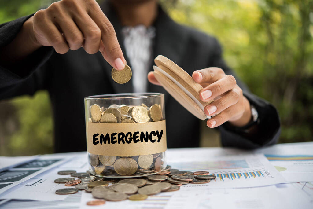 Saving Money Putting Coins Into A Jar.