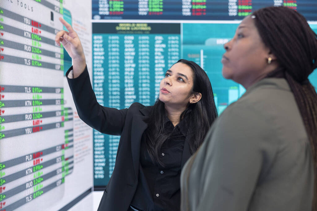Diverse Team Of Employees Examine Infographics On A Big Screen