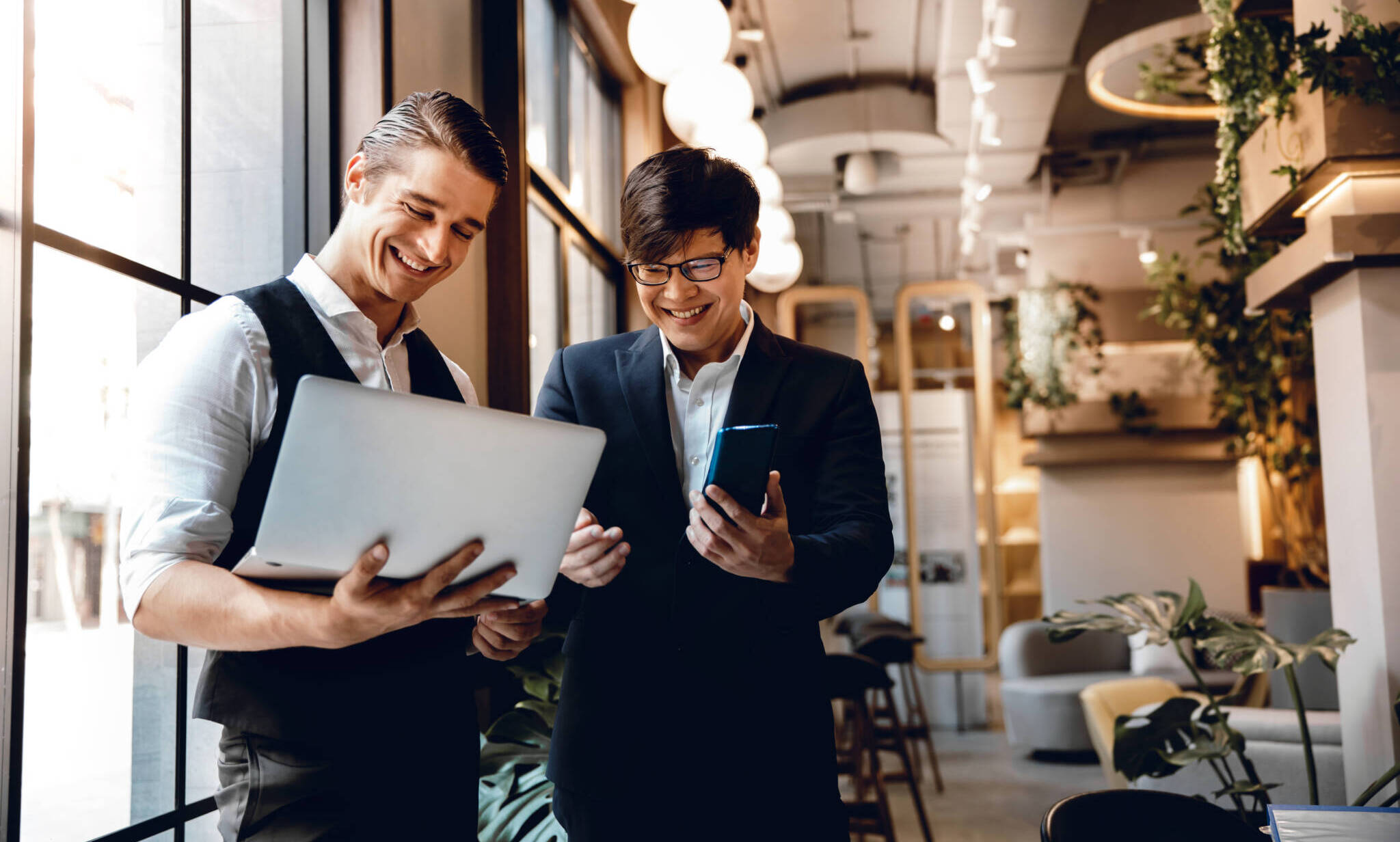Two Businessman Working Together On Computer Laptop In Creative Workplace. Happy Business People
